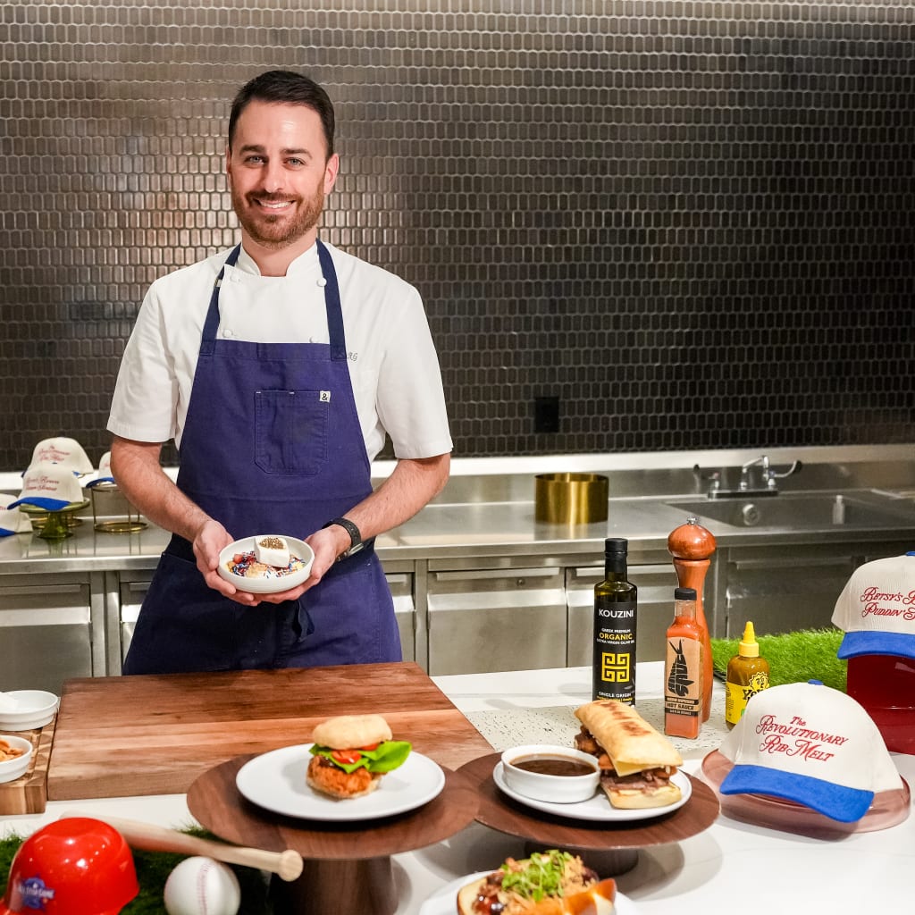 Chef Rich surrounded by donut chicken sandwiches, pretzel hot dogs and other off-the-wall meals at Aramark's test kitchen