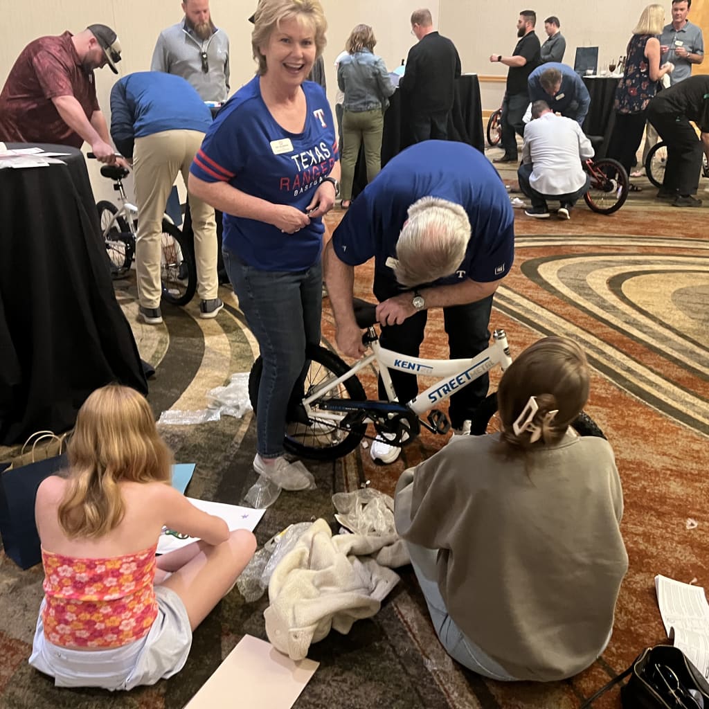 Volunteers help build bicycles at the JW Marriott Desert Ridge on Friday. (Texas Rangers)