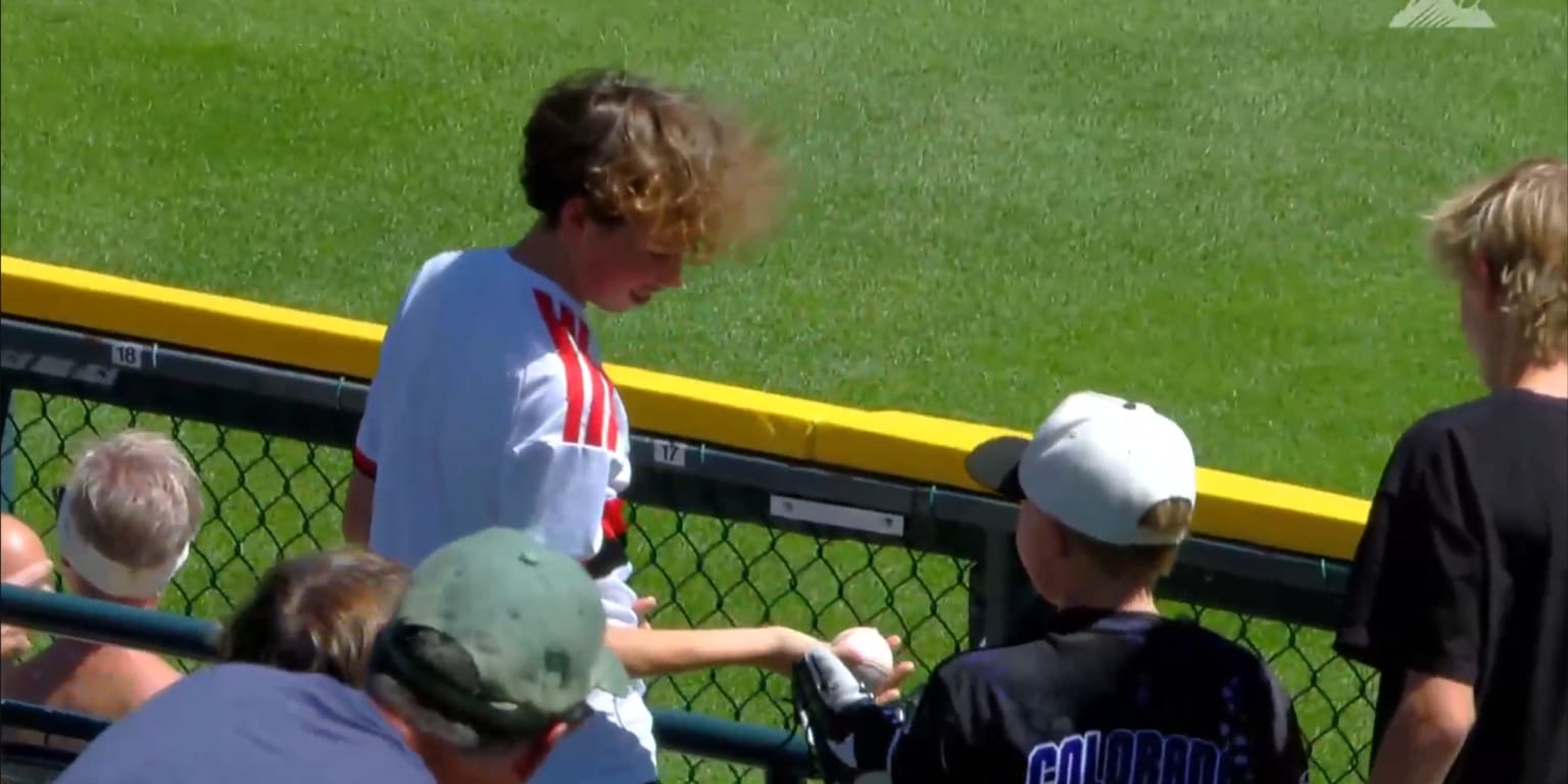 Young fan immediately hands ball to a kid, who thanks him with a hug