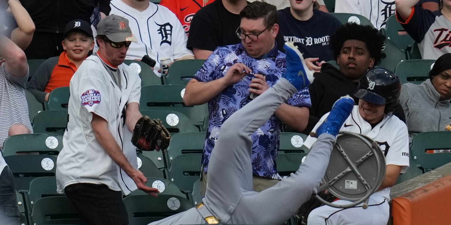 Collins (knee) exits after running into, tumbling over LF railing at Comerica Park