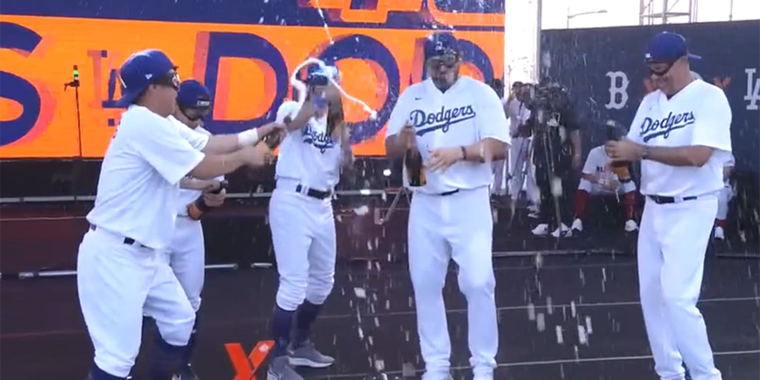 Four players in Dodgers uniforms celebrate after their victory