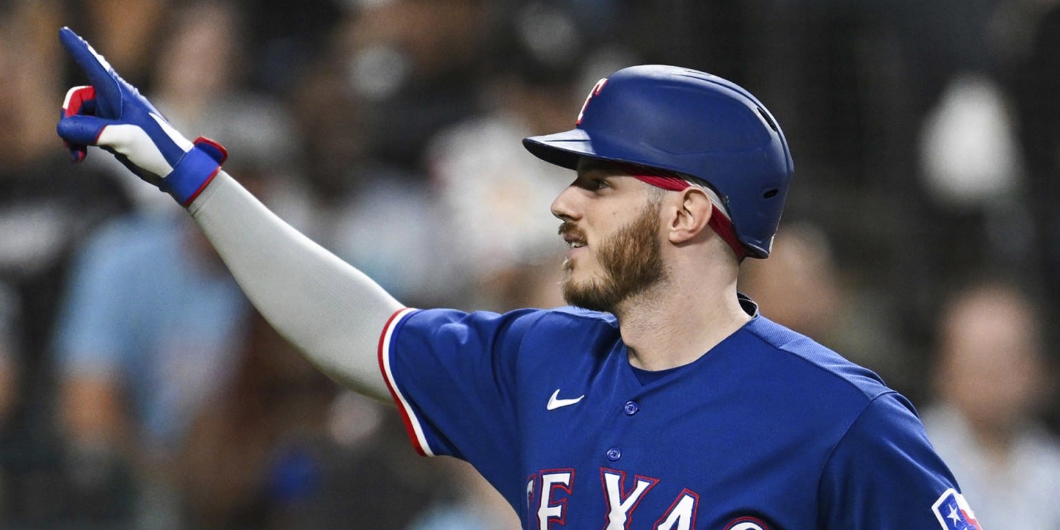 Jonah Heim of the Texas Rangers reacts in the dugout after scoring