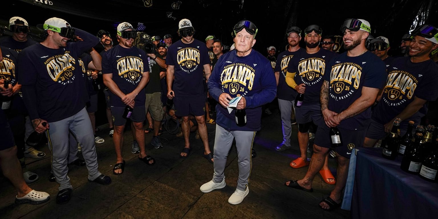 Milwaukee Brewers manager Pat Murphy and players gather with celebratory bottles after clinching the 2026 NL Central division