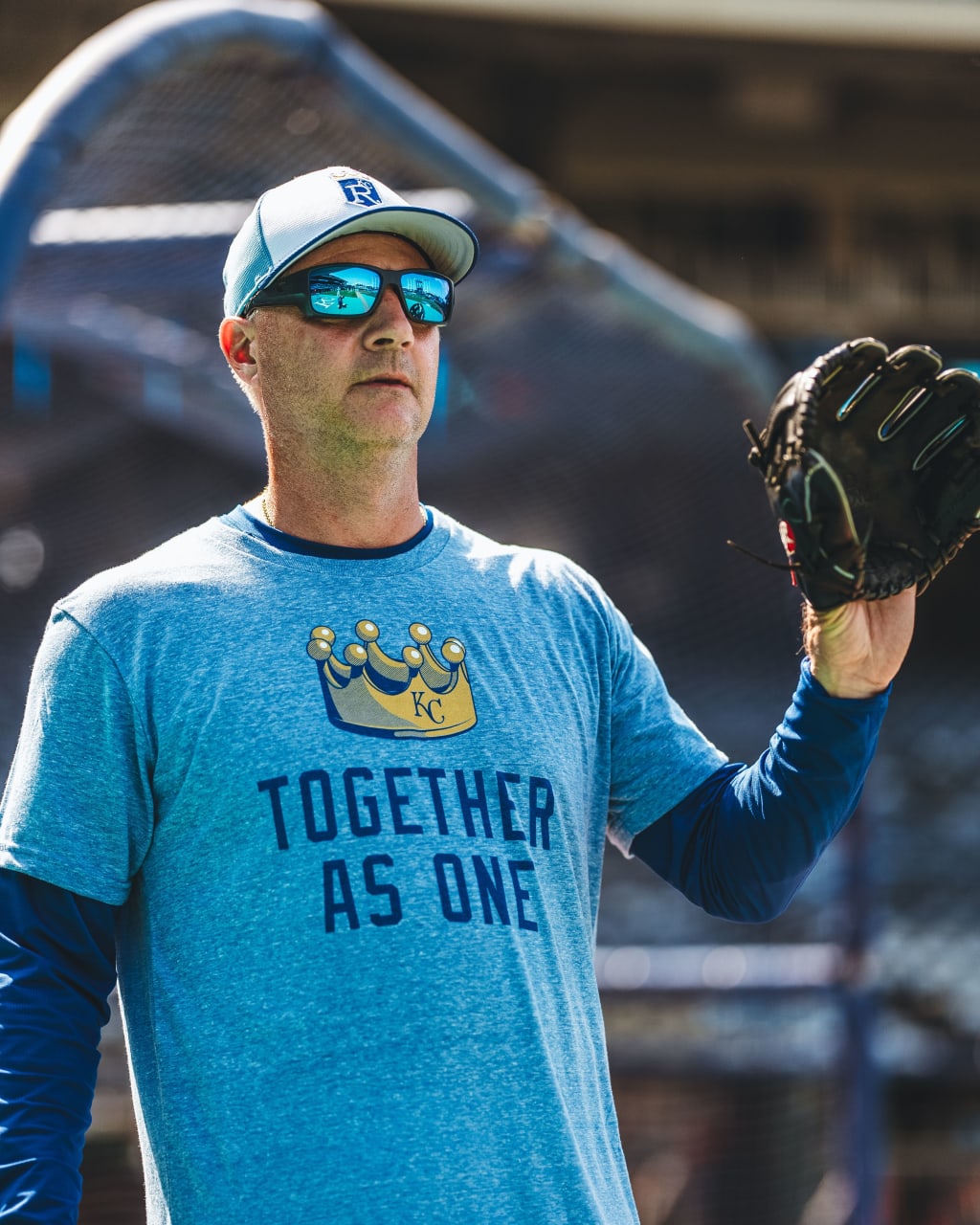 Royals manager Matt Quatraro wears the 'Together as One' T-shirt during pregame warmup drills.