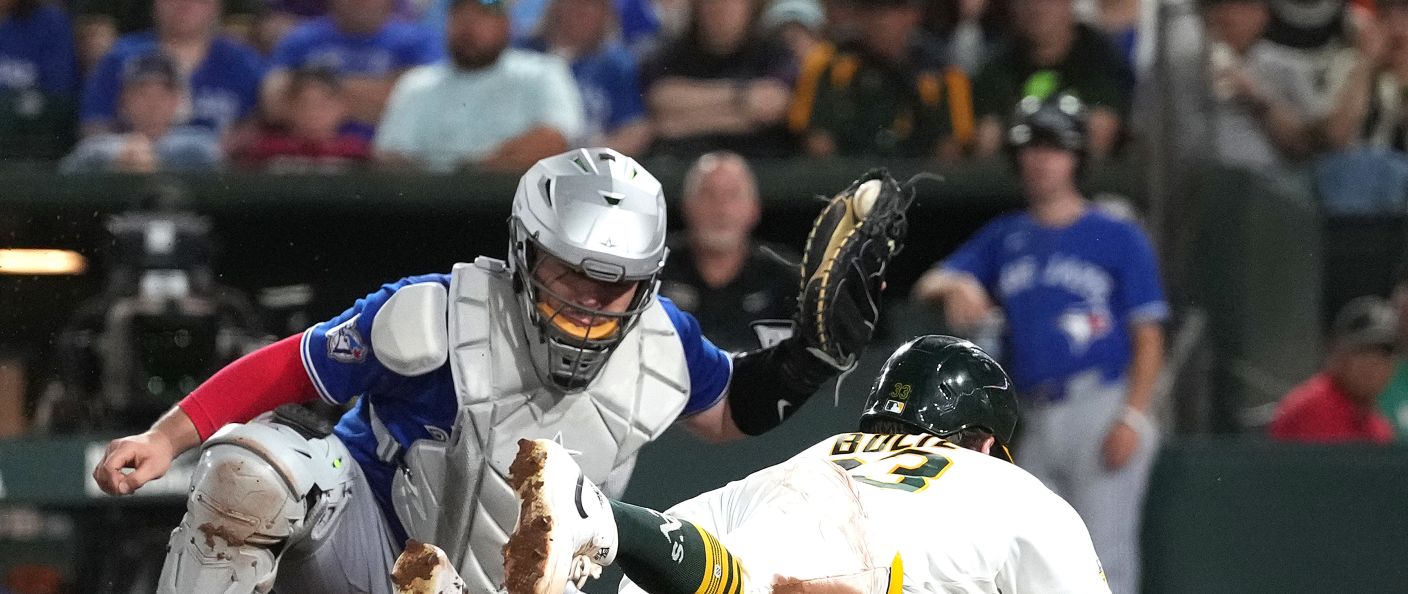 Le receveur des Blue Jays tente de toucher un coureur des Athletics qui glisse vers le marbre, à West Sacramento.