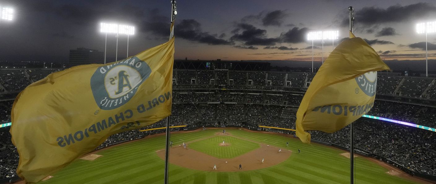 Les drapeaux de champions des Athletics flottent au-dessus de l'Oakland Coliseum plein, au crépuscule, lors de la dernière série du club à Oakland.