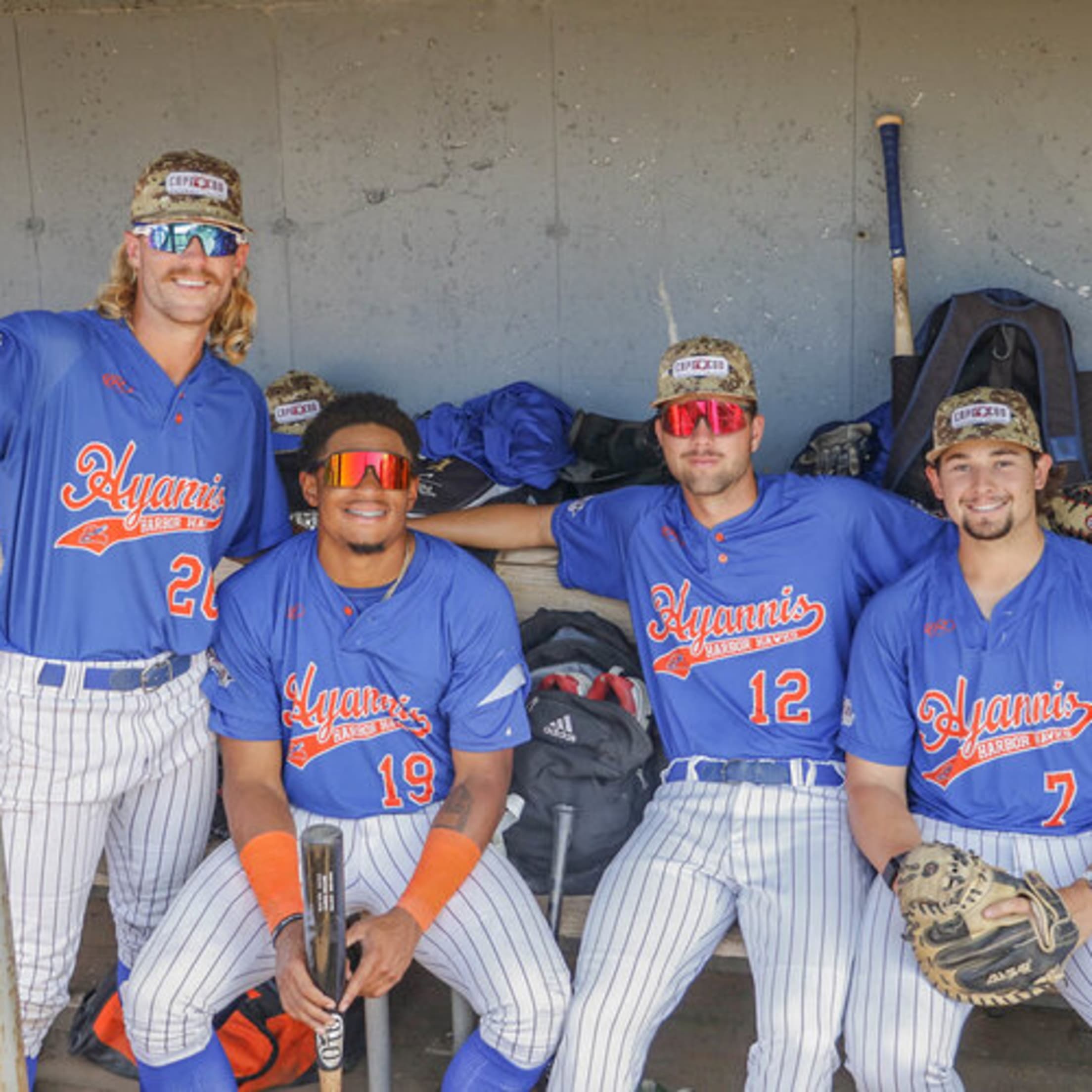 Hyannis Harbor Hawks players smile for a photo in the dugout.
