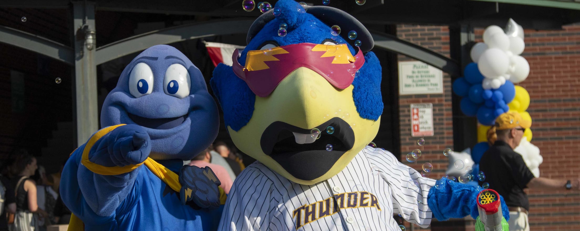 Thunder mascots Cloudman and Boomer in front of the stadium.